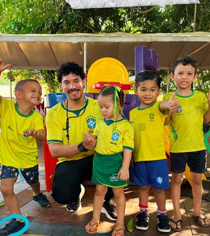 Professor e crianças do Recriar no pátio da escola